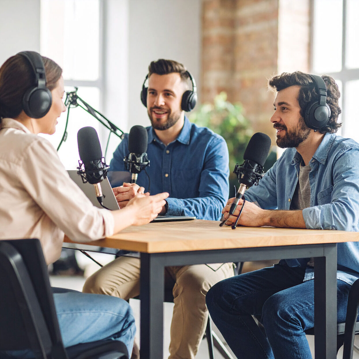 video-production-team-filming-a-video-podcast-with-3-people-seating-in-a-modern-podcast